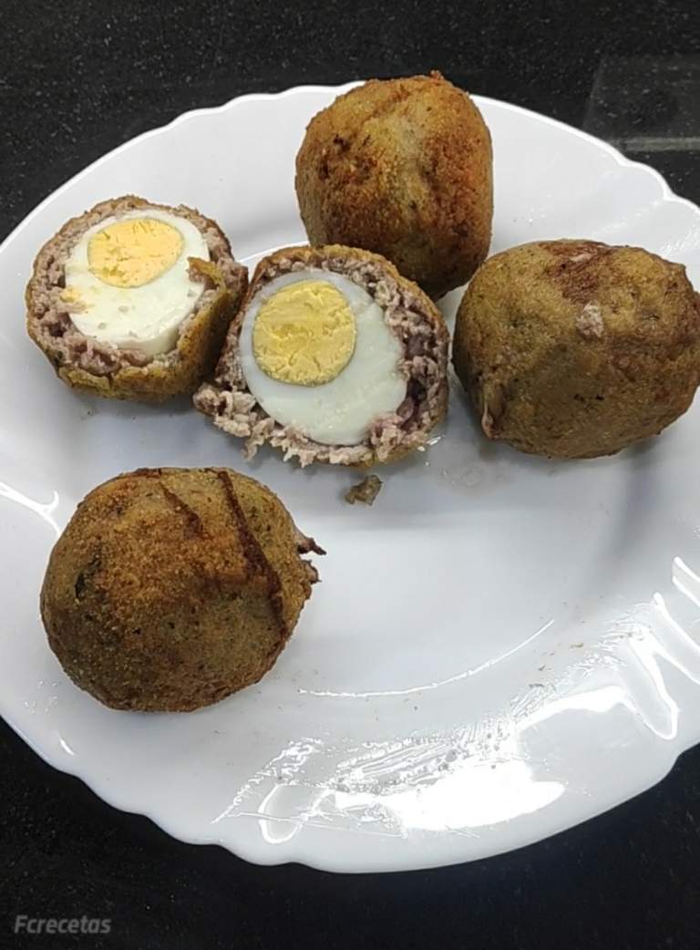 en un plat quatre ous a l'escocesa i un obert per la meitat