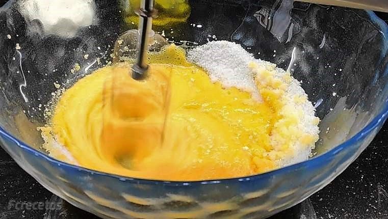 en un bol batiendo huevos y azúcar