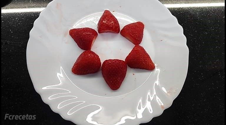 fresones en un plato, seis mitades cortadas formando círculo