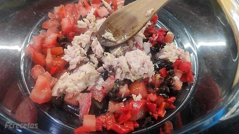 atún desmigado, olivas troceadas y tomate troceado en un recipiente