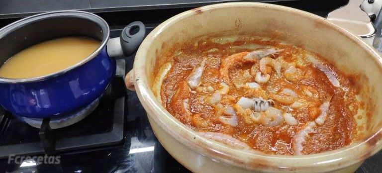 cassola d'arròs i al costat una altra cassola amb el brou calent