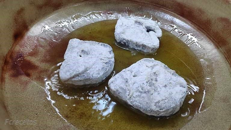Sofriendo rodajas de merluza enharinadas