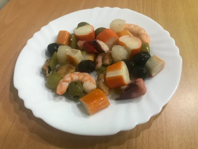 Salpicón de marisco un plato con surimi, gambas, pimiento, aceitunas y pulpo