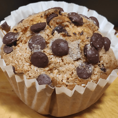 una magdalena con papel blanco y varias pepitas de chocolate