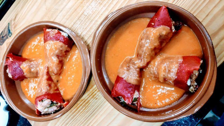 dos cazuelas de barro con tres pimientos del pquillo en salsa