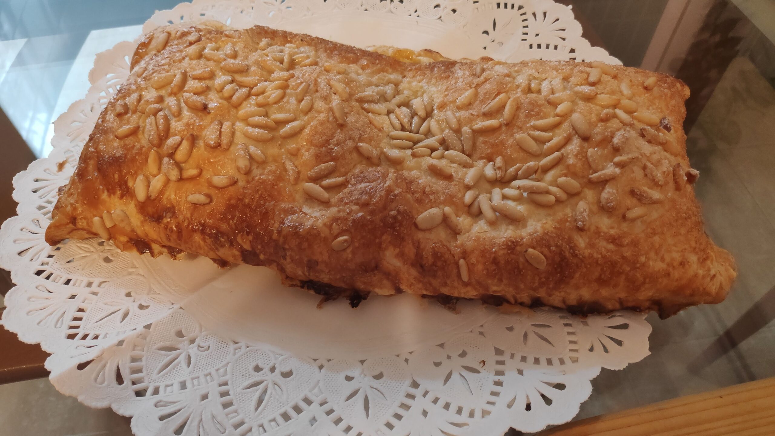 una coca de hojaldre rellena de crema