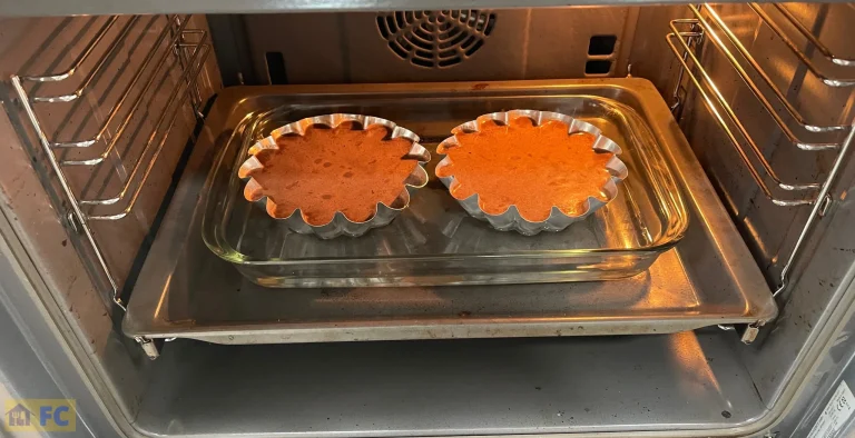 En la safata del forn un recipient amb aigua i les flameres per coure al bany de maria