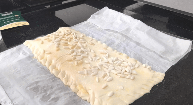 pinyons afegits a la coca de pasta de full i sucre per sobre