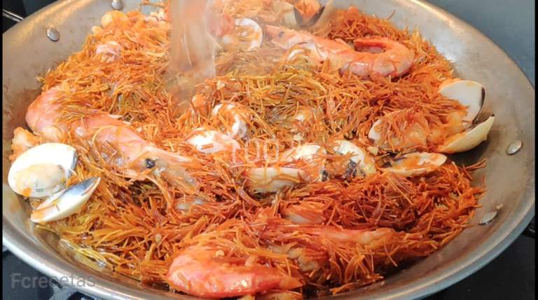 afegint el brou de peix a la fideuà de mica en mica