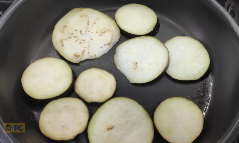 cocinando las rodajas de berenjenas en la sartén