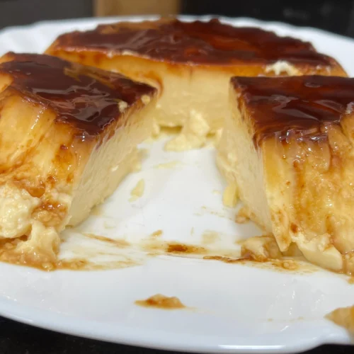 en un plato blanco un flan de queso con una porción cortada