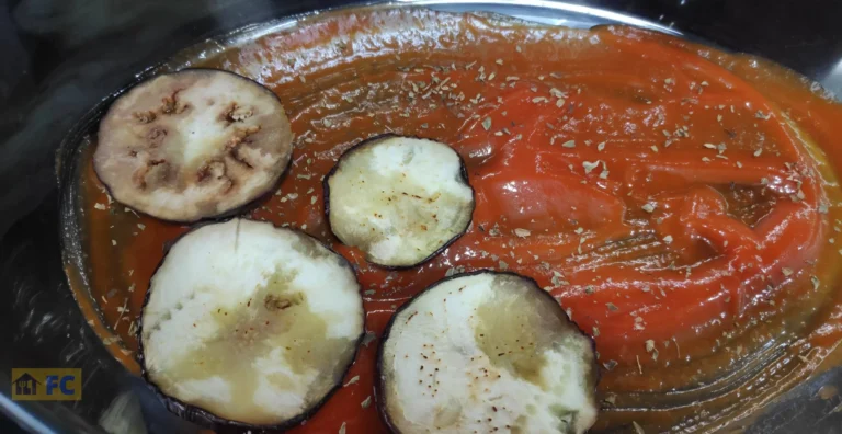 en la fuente una capa de tomate frito y berenjenas en rodajas encima