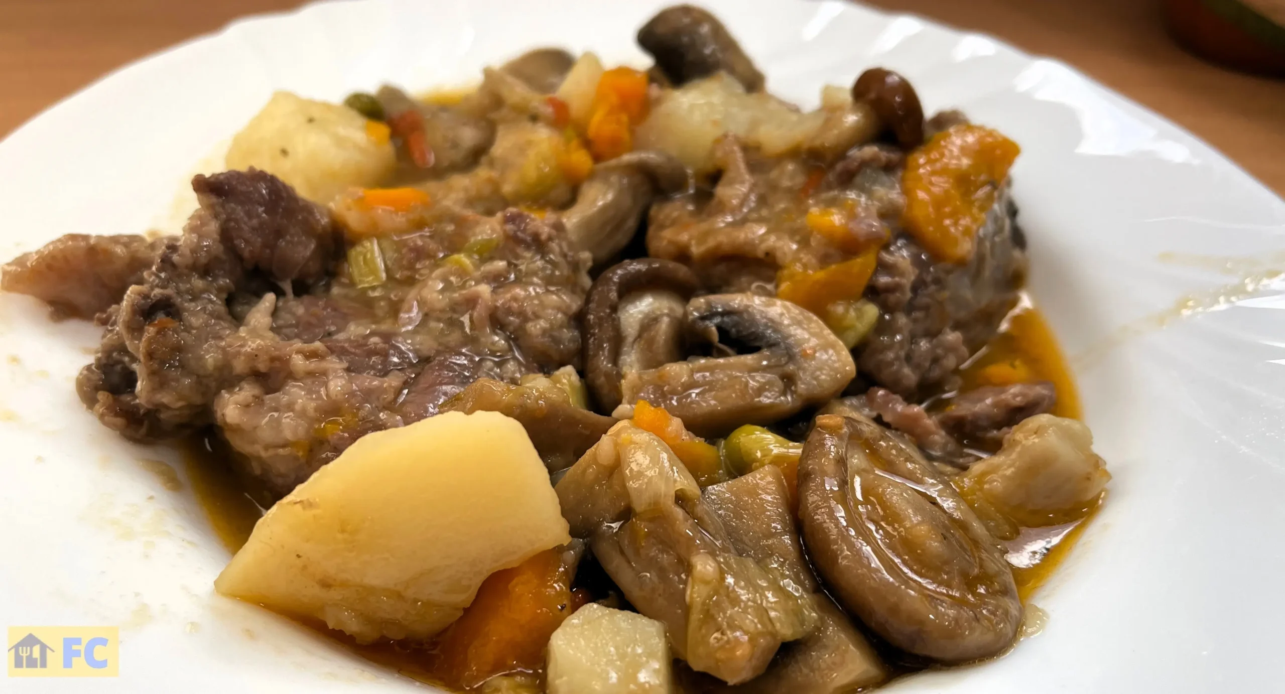 un plato con carrilleras con setas y patatas