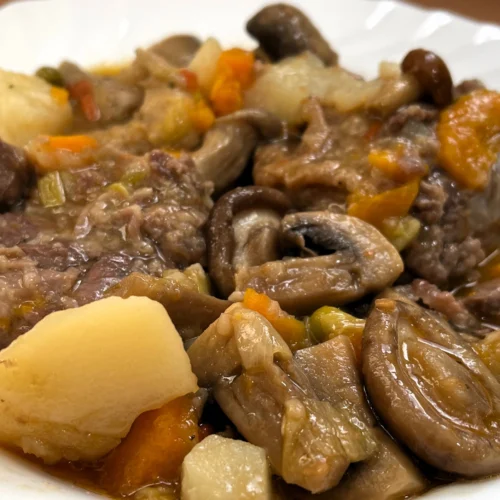 un plat de galtes amb salsa i bolets