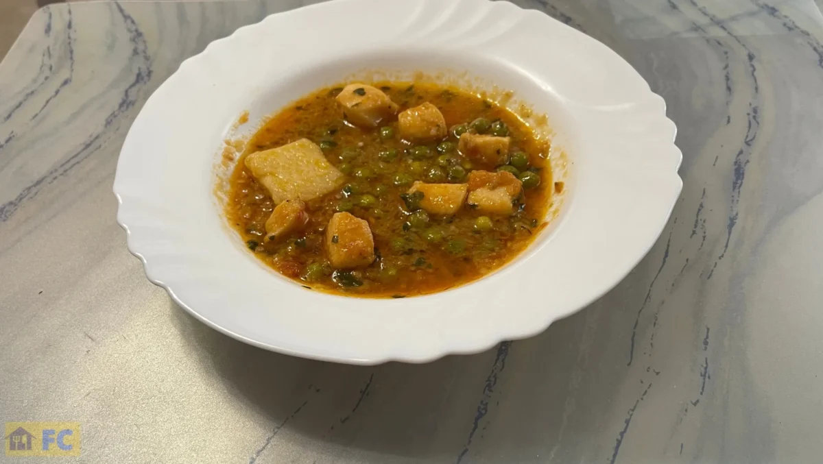 un plato con guiso de potón con guisantes y patatas