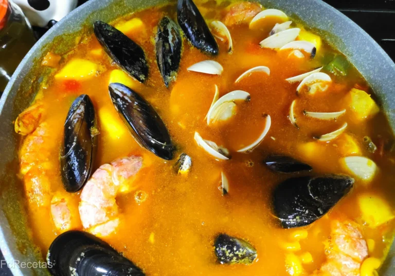 una cassola que se estan cuinant fideos amb brou i marisc