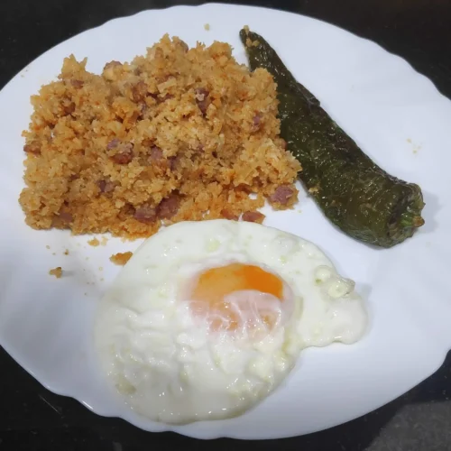 un plat amb molles de coliflor un pebrot verd i un ou ferrat