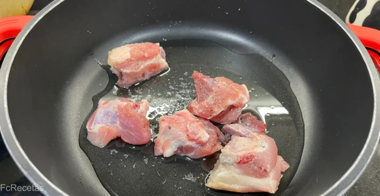 en la cazuela sofriendo costillas troceadas