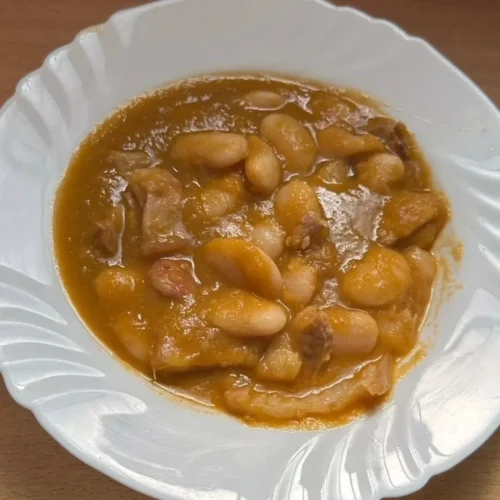 en un plato blanco fudiones estofados, sobre una base de madera