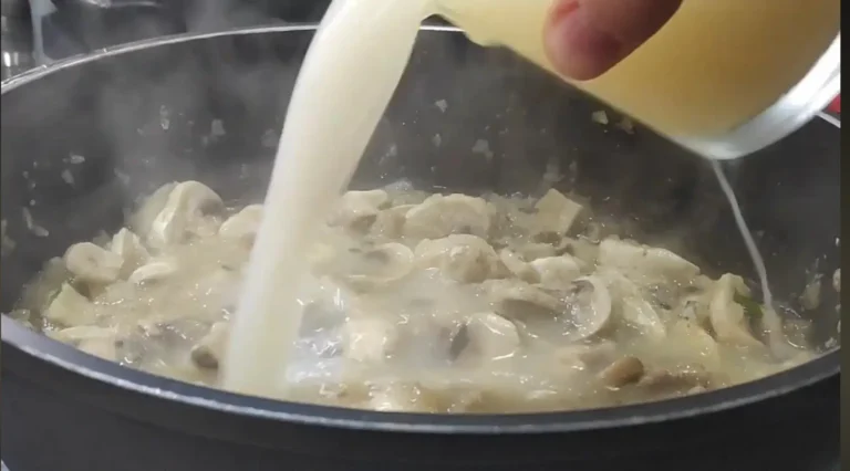 añadiendo el caldo al guiso de albóndigas en salsa de champiñones
