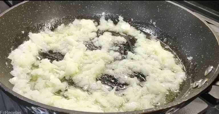 sofriéndo cebolla picada en la sartén con mantequilla