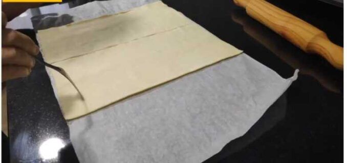 pinchando con un tenedor la base de la coca de hojaldre